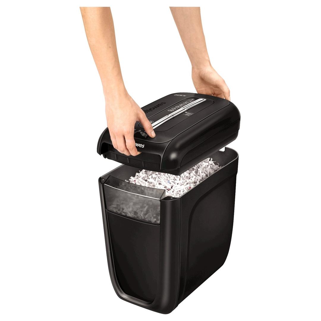 Destructeur de documents confidentiels P4 Coupe croisée Powershred 60Cs 4 x 50 mm FELLOWES — Bloc de coupe soulevé à deux mains au-dessus de la corbeille