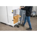 Combinaison destructeur-presse à balles P3 Coupe croisée Forte capacité SP 4040 V Powerline 5,8 x 50 mm HSM - Opérateur évacuant une balle de papier compressé avec le chariot d'éjection de la combinaison HSM Powerline SP 4040 V