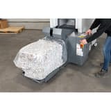 Combinaison destructeur-presse à balles P3 Coupe croisée Forte capacité SP 5080 Powerline 6 x 40-53 mm HSM - Opérateur sortant une balle de papier compressé de la presse de la combinaison HSM Powerline SP 5080